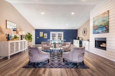 a living room with a blue accent wall and a table with chairs