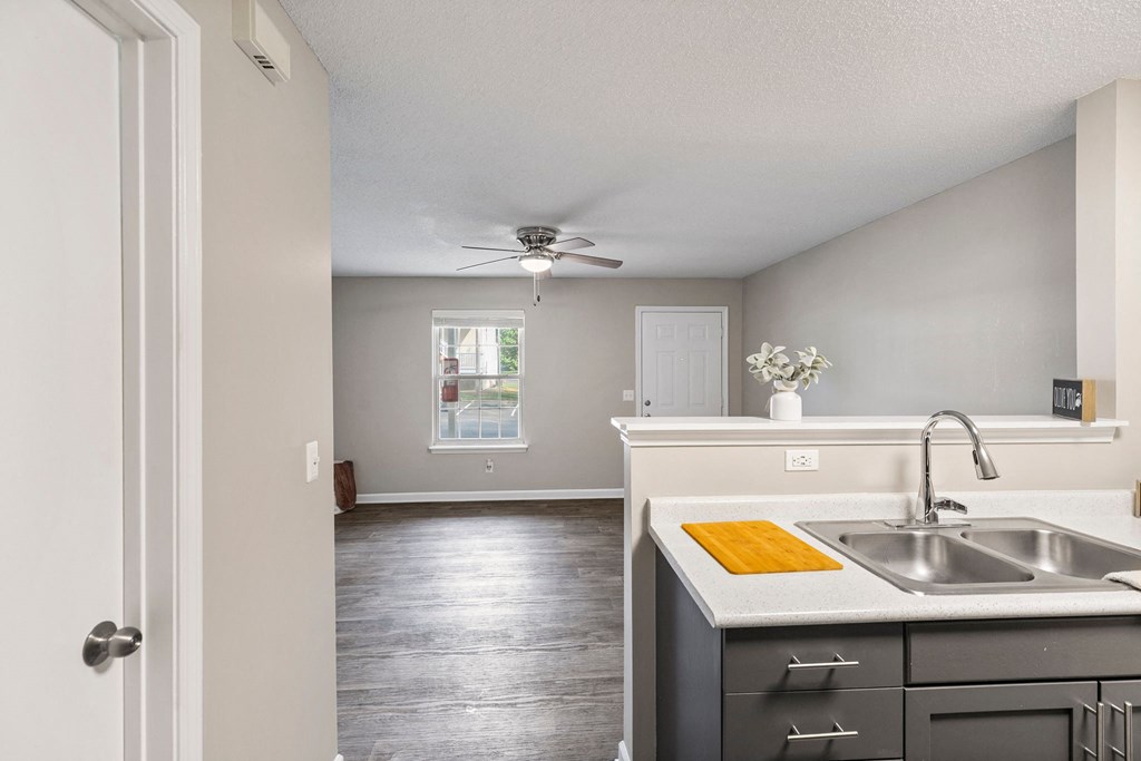 an empty kitchen with a sink and a ceiling fan
