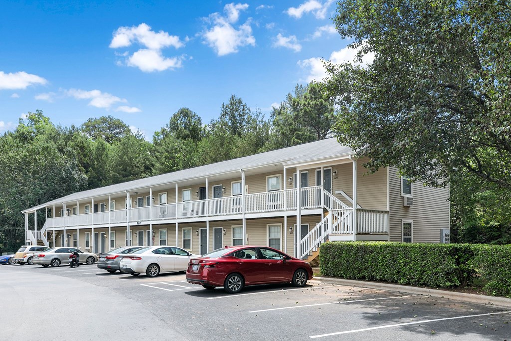 a parking lot with cars in front of an apartment building