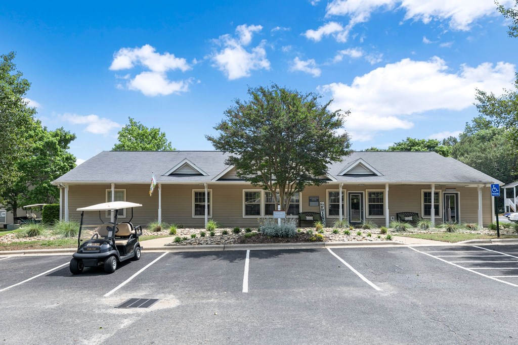 a clubhouse with a golf cart in the parking lot