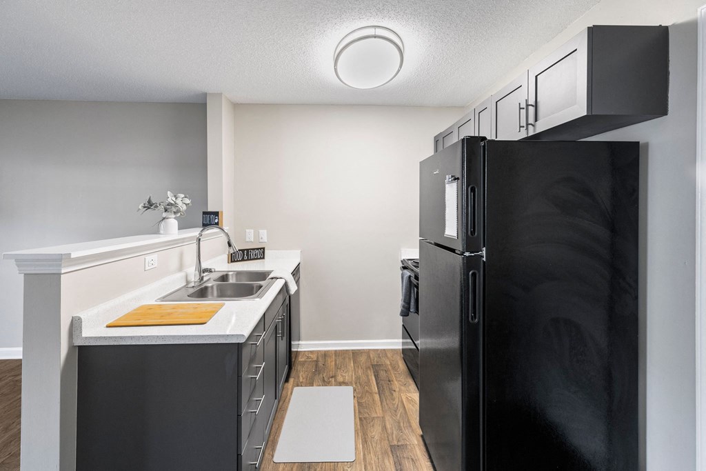 a kitchen with black appliances and a sink and refrigerator