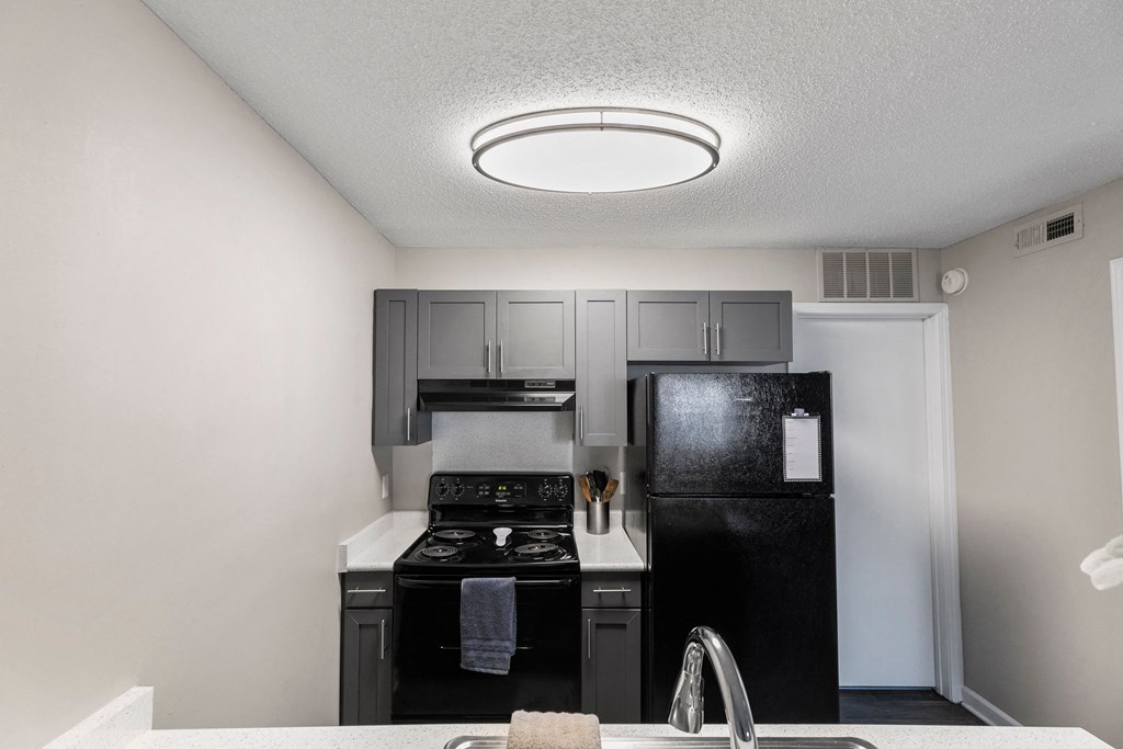 A kitchen with black appliances and a white sink.