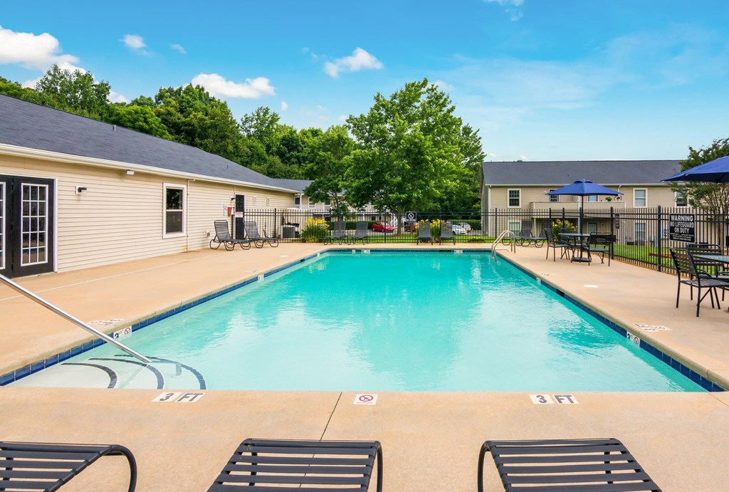 A swimming pool with a blue sky and clouds in the background.