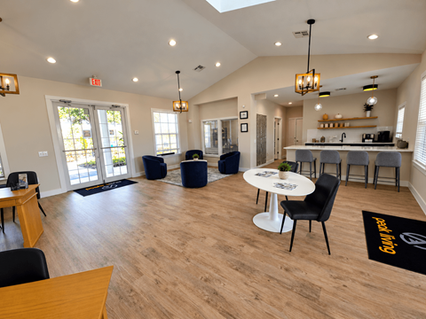 A spacious room with a dining table and chairs, a kitchen area, and a bar area.