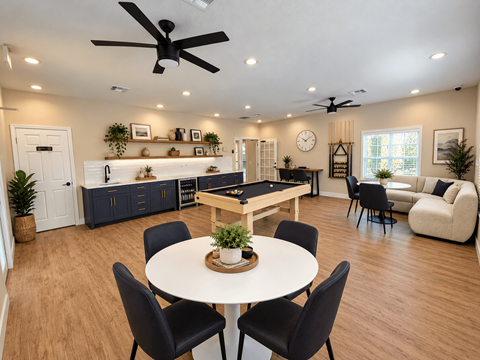 A dining room with a white table and black chairs.