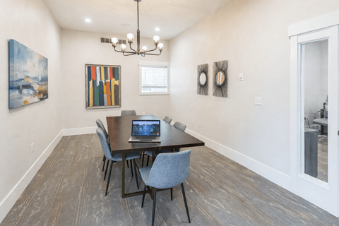 A dining room with a table and chairs.