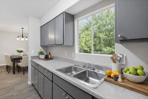 A modern kitchen with a large window and a dining table.