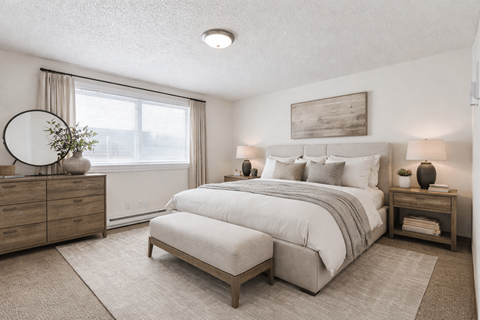 A bedroom with a large bed, a dresser, and a nightstand.