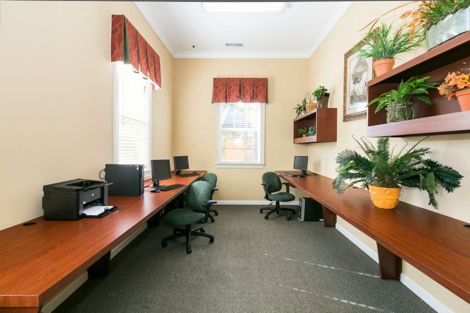 a conference room with desks and chairs and plants