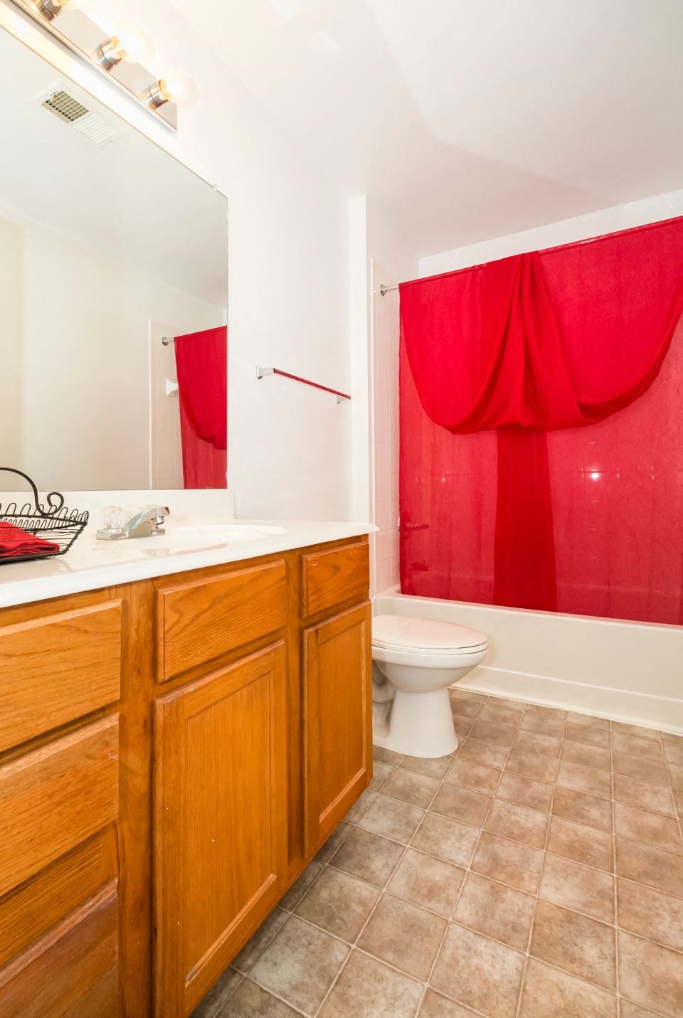a bathroom with a toilet and a red curtain