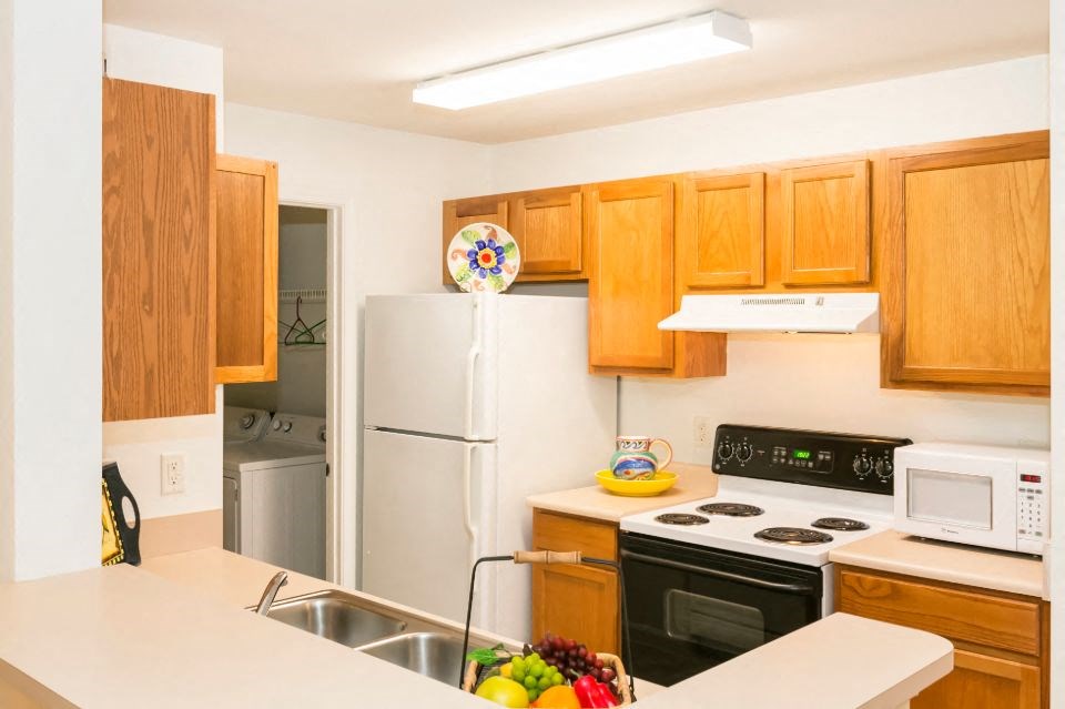 a kitchen with a white counter top and a refrigerator