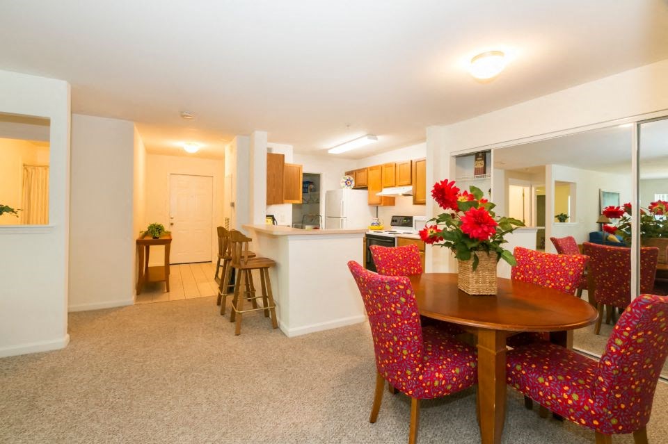 a dining room and kitchen with a table and chairs