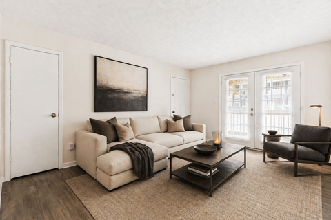A living room with a couch, a chair, and a coffee table.