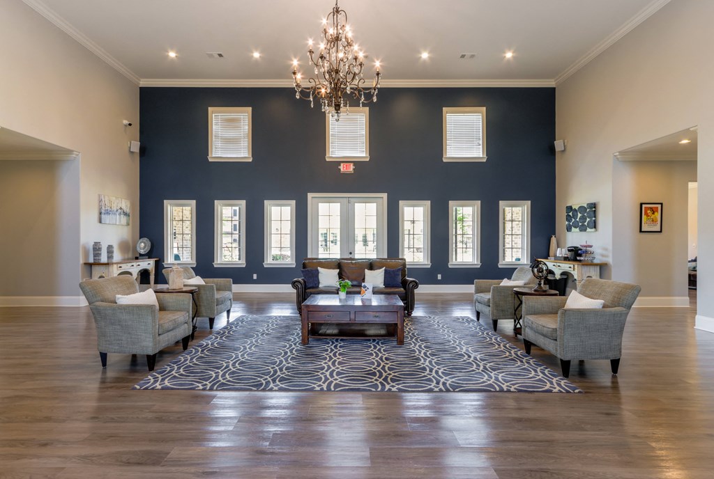 A large room with a chandelier, couches, and a rug.