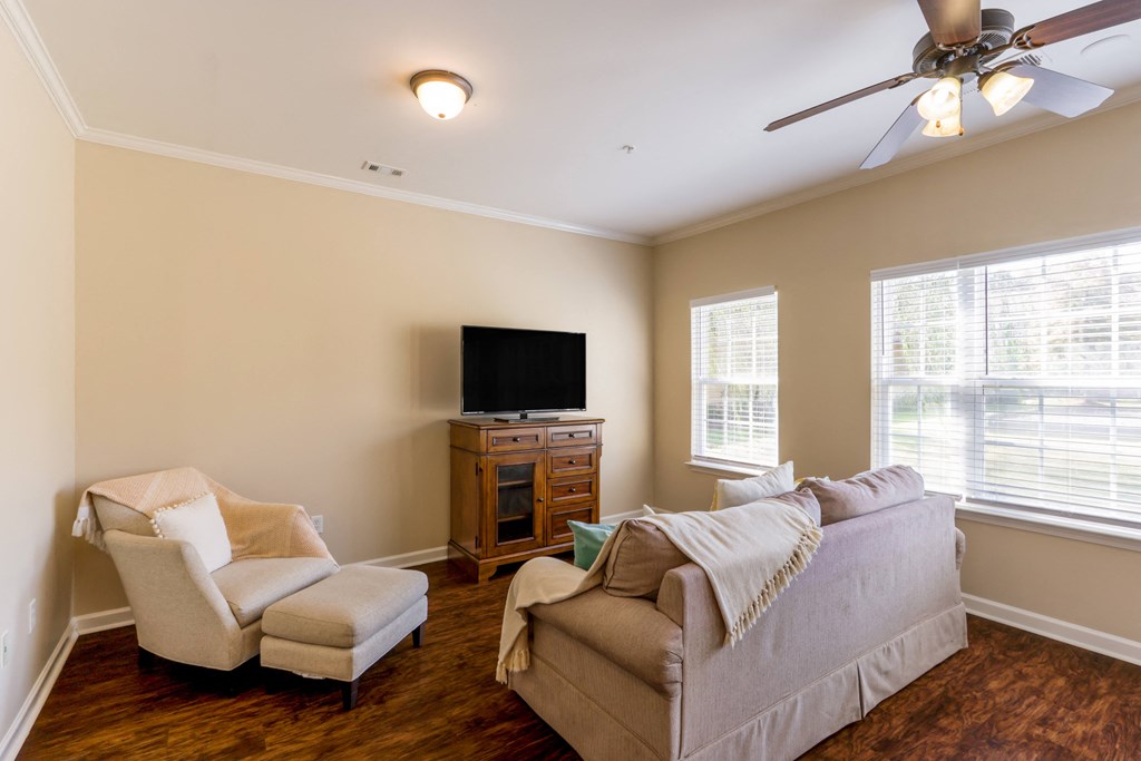A living room with a couch, chair, and television.
