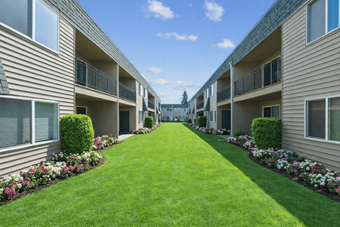 A long row of apartment buildings with green lawns in between.
