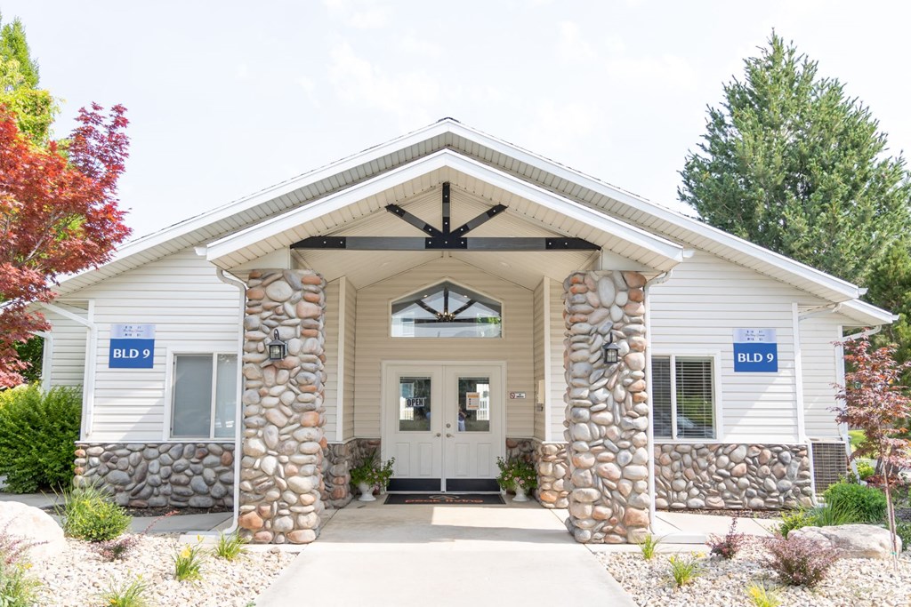 the front of a white building with a stone facade and a white door