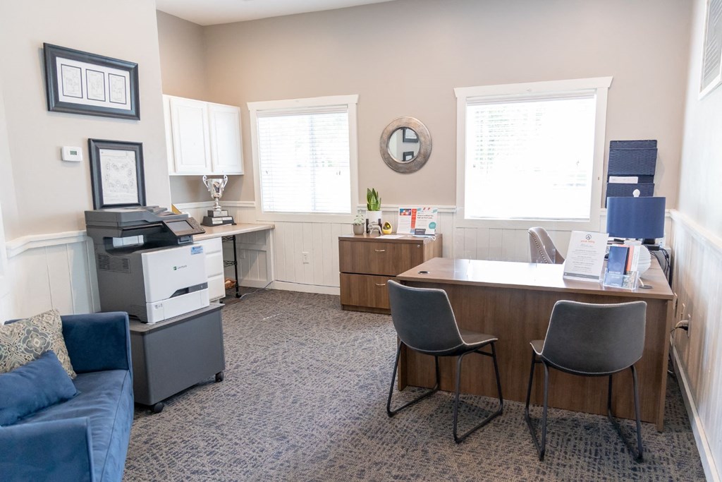 an office with a desk and a couch and a printer