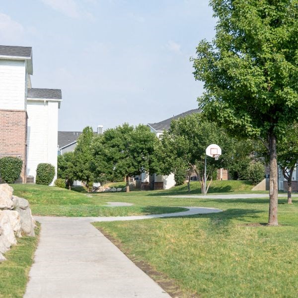 a sidewalk in a neighborhood with a basketball court