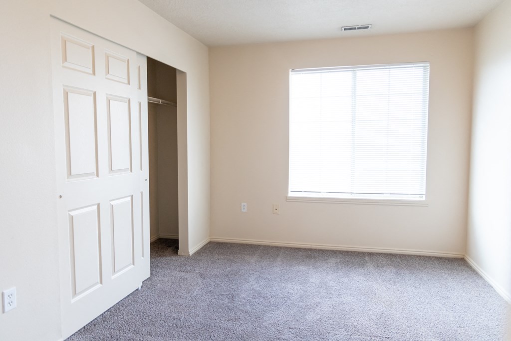 an empty room with a white door and a window