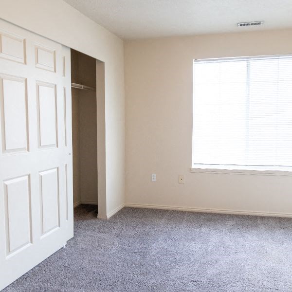 an empty room with a white door and a window