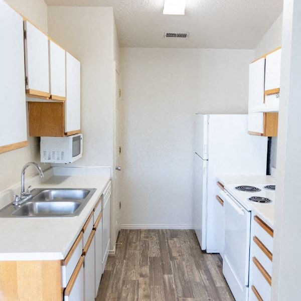an empty kitchen with a sink and a refrigerator
