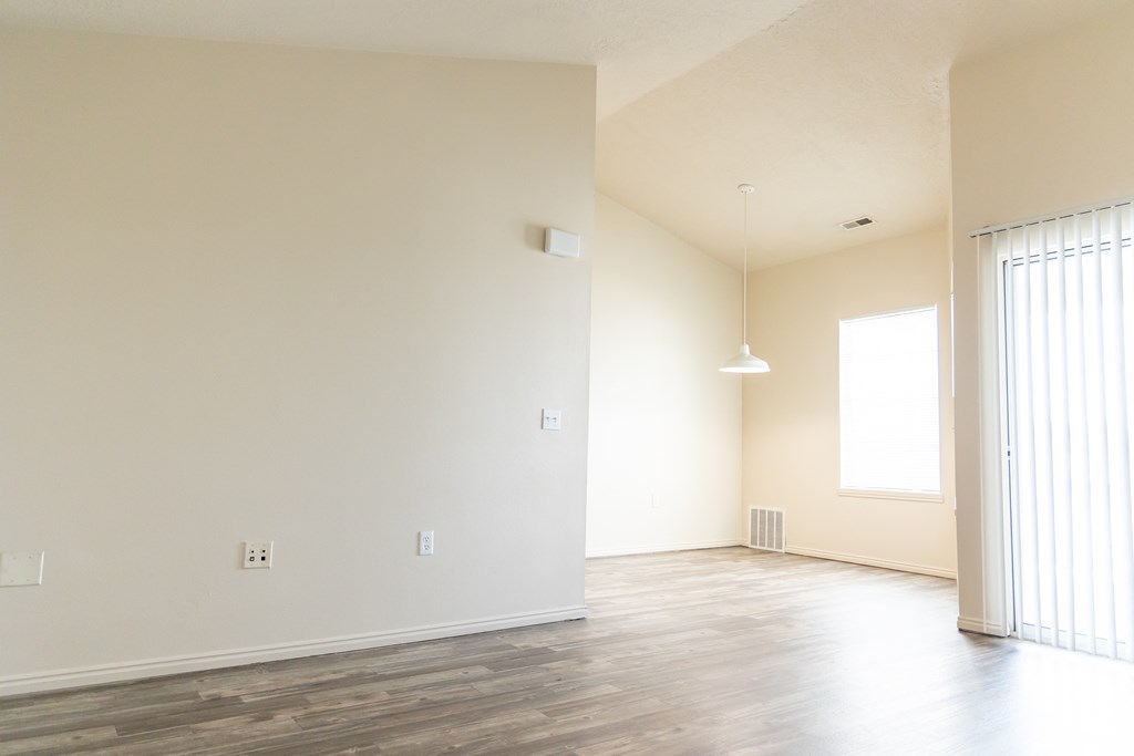 an empty living room with white walls and wood floors