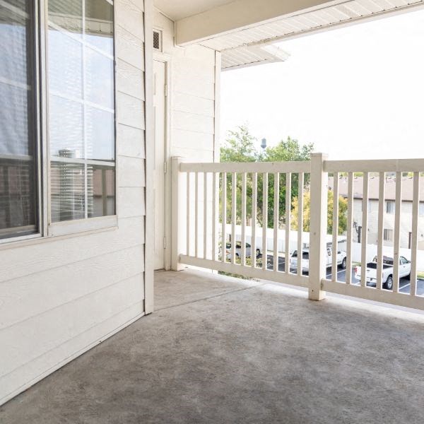 a porch with a white railing and a white house