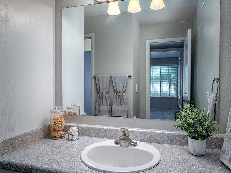 A bathroom with a white sink and a mirror.at Creekview, Midvale, UT 84047