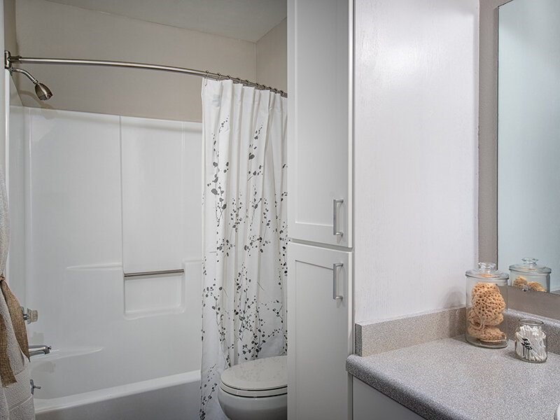 A white bathroom with a toilet, sink, and shower curtain.