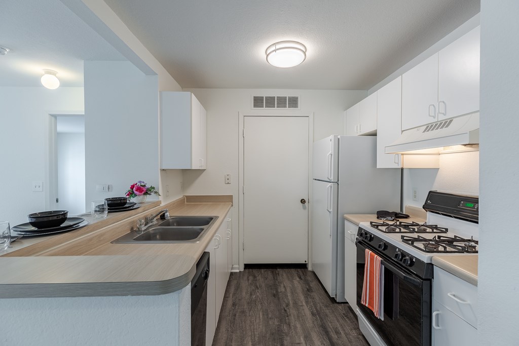 a kitchen with white cabinets and stainless steel appliances and a white refrigerator