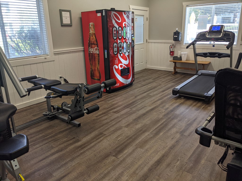 a gym with a coca cola fridge in the corner