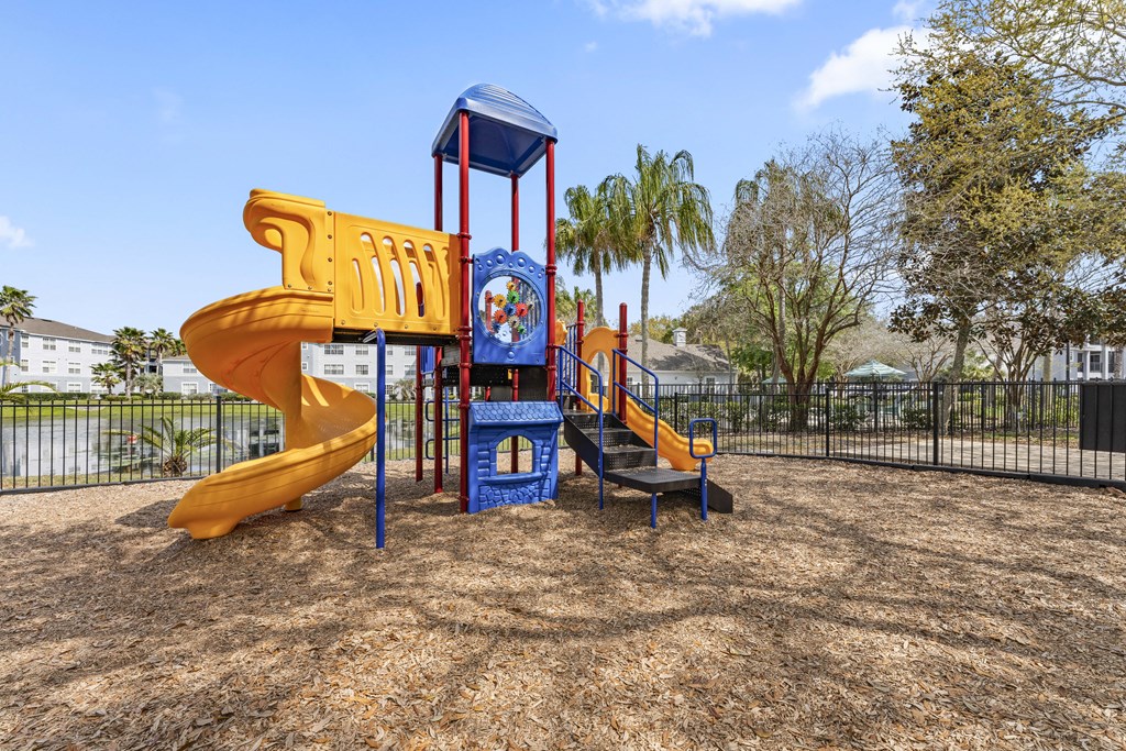 a playground with a yellow slide and a blue playset