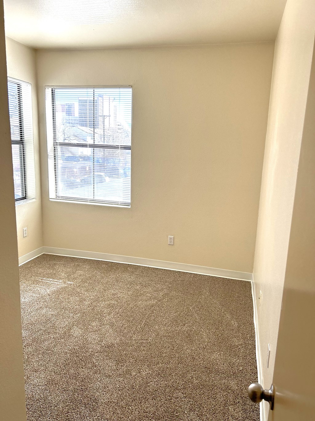 an empty room with carpet and a window