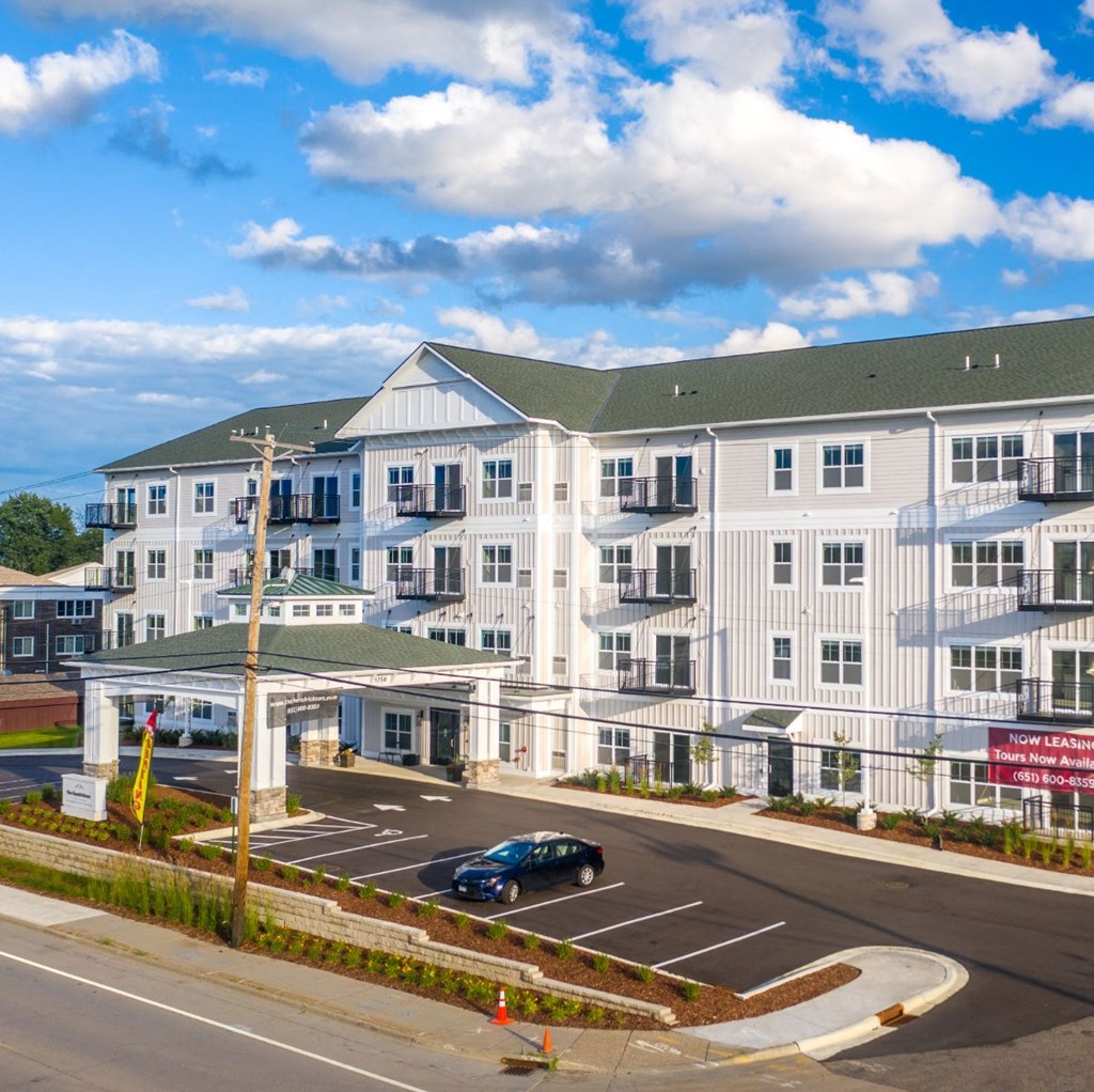 a large apartment building with a car parked in a parking lot