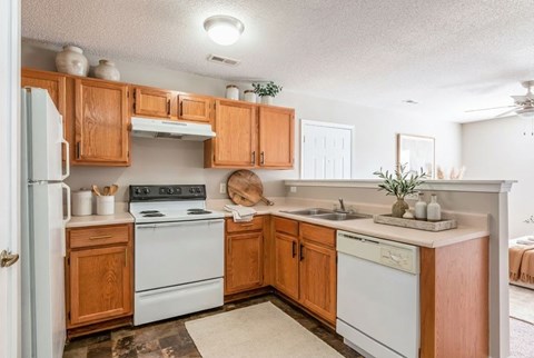 A kitchen with wooden cabinets and white appliances.
