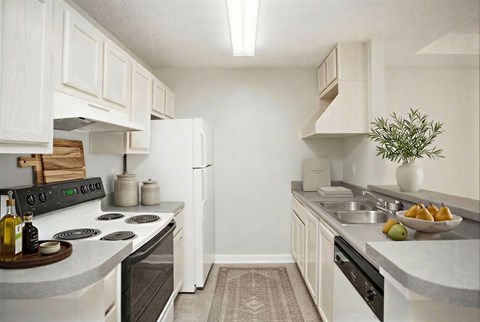 A kitchen with white cabinets and a black stove top.