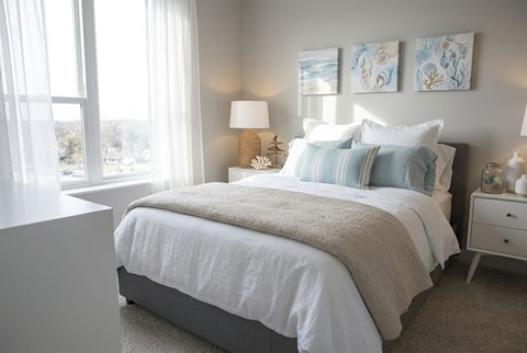 A bedroom with a large bed and two lamps.