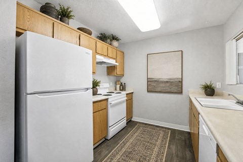 A kitchen with a white refrigerator and wooden cabinets.