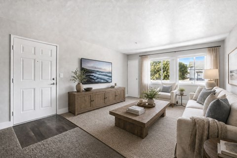 A living room with a large flat screen TV mounted on the wall.