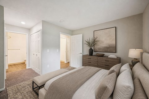 A bedroom with a large bed and a painting on the wall.