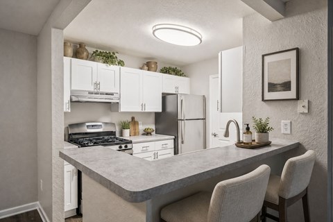 A kitchen with a counter and chairs.
