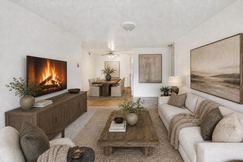 A modern living room with a fireplace and a painting on the wall.