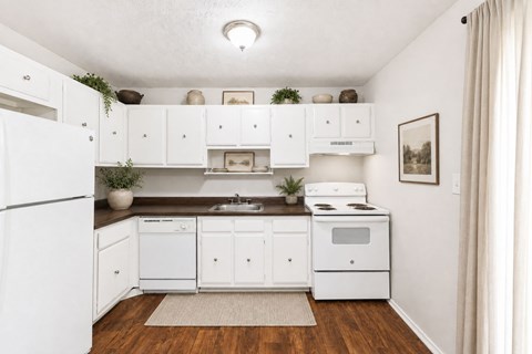 A small kitchen with white appliances and cabinets.