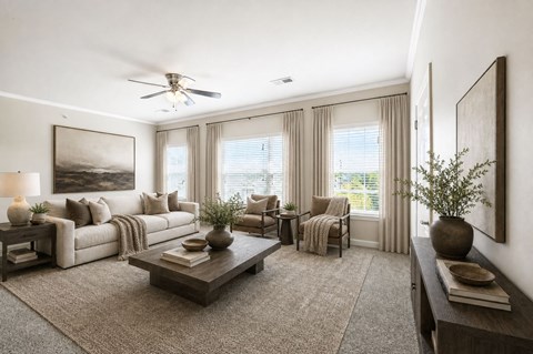 A well-lit living room with a large painting on the wall and a ceiling fan.