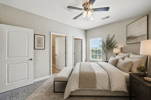 A bedroom with a large bed and a ceiling fan.