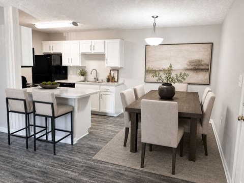 A kitchen with a dining table and chairs.