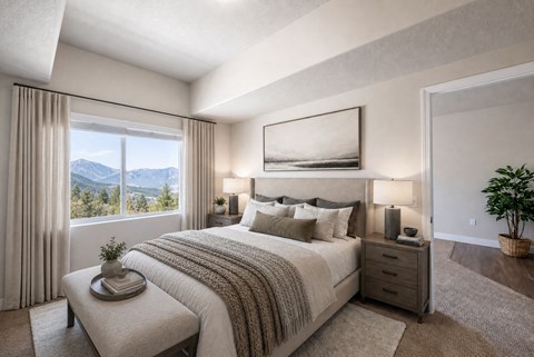 Master bedroom with mountain views and neutral decor at The Ellison Apartments, Layton, Utah