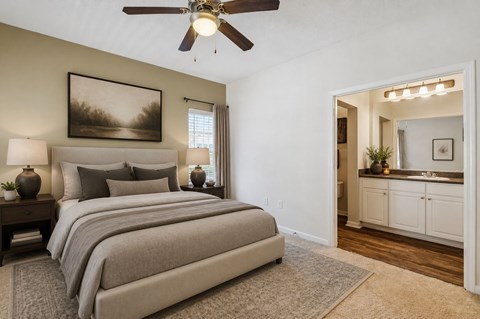A bedroom with a large bed and a ceiling fan.
