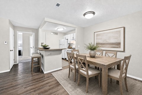 A dining room with a wooden table and chairs.